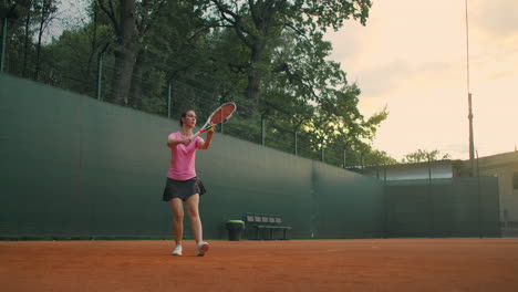 Para-El-Entrenamiento-De-Tenis,-Una-Niña-Se-Encuentra-En-La-Línea-De-Servicio-Central.-Golpea-La-Pelota-En-La-Cancha.-Atender.-Plano-General.